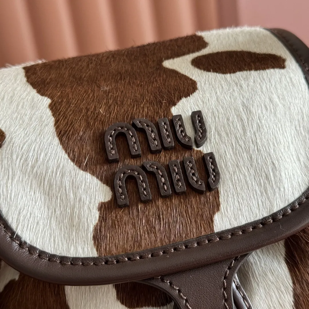 Miu 牛仔 棕白撞色的奶牛纹皮毛材质自带吸睛buff 搭 标志性 雙肩包 实用雙肩款